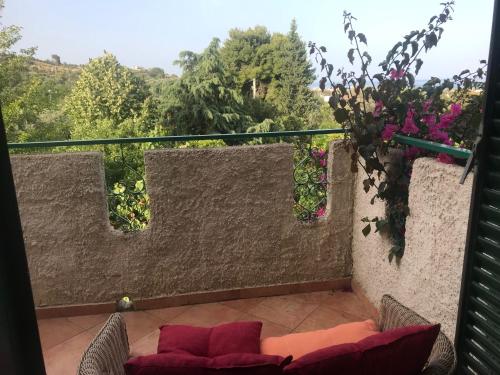 a balcony with a couch and flowers and a view at Arancetodamare_ZEUS in Trebisacce
