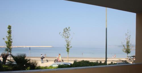 a view of a beach from a window of a building at Appartamenti Sole 1 in Alghero