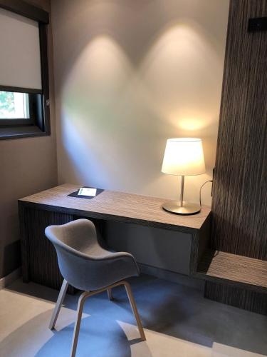 a room with a desk with a chair and a lamp at Hotel Balneario de La Virgen in Jaraba