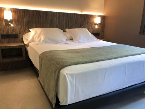 a large white bed in a hotel room at Hotel Balneario de La Virgen in Jaraba