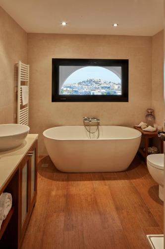 a bathroom with a tub and two sinks and a television at Bab el Oued Villa Ibiza in Puig D’en Valls