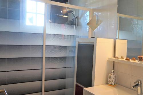 a bathroom with a glass shower door in a room at TELLA in Ploemeur