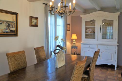 une salle à manger avec une table, des chaises et un lustre dans l'établissement TELLA, à Ploemeur