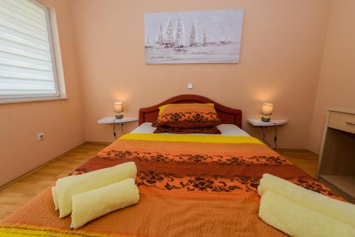 sypialnia z dużym łóżkiem z dwoma stołami w obiekcie Milkica w mieście Kaštela