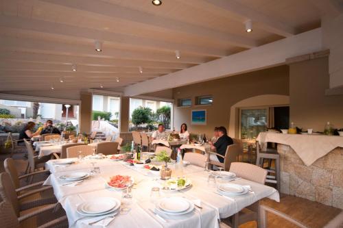 a restaurant with tables and chairs and people eating at Hotel Nibaru in Porto Cervo