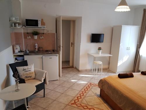 a bedroom with a bed and a kitchen with a table at Éden Villa Apartmanház in Balatonfüred