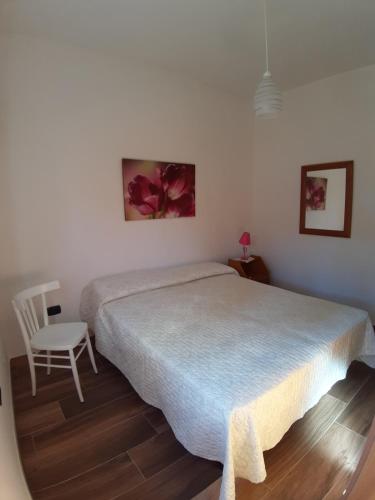 ein Schlafzimmer mit einem großen Bett und einem Stuhl in der Unterkunft Casa vacanza nel cuore del Salento in Parabita