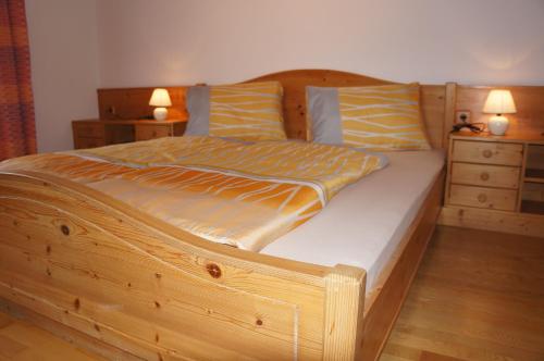 - un lit en bois dans une chambre avec 2 tables de chevet dans l'établissement Ferienhaus Bergwelt, à Liesing
