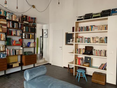 a living room with a couch and shelves of books at Casa VerbaVolant in Syracuse