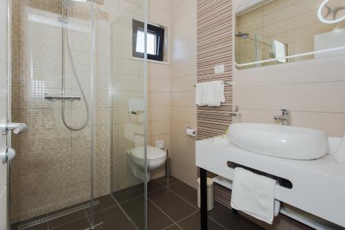 a bathroom with a sink and a toilet and a shower at View Villas Collection in Vinišće