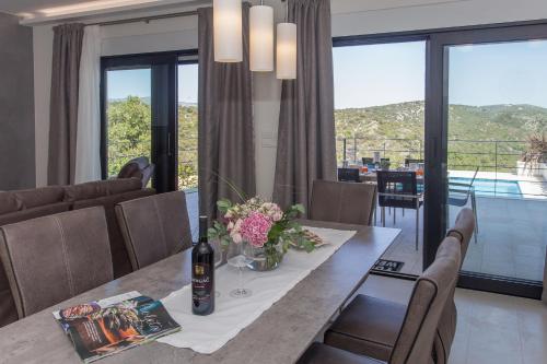 a dining room with a table with a bottle of wine at View Villas Collection in Vinišće