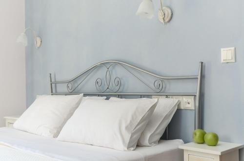 a bed with a silver headboard and white pillows at Naxos Luxury Villas in Mikri Vigla