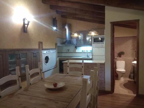 Una cocina con una mesa, un fregadero y una estufa. en El Corralón - Casa Rural en Sigüenza, en Sigüenza
