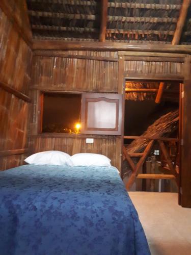 a bedroom with a bed in a wooden house at Hostal Villa Brisa in Ballenita