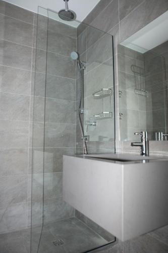 Un baño con ducha con bañera y lavabo. en Dionysos Central, en Pafos