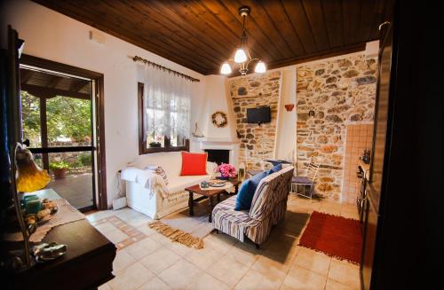 a living room with a couch and a stone wall at Millers Guest House in Kalyves Poligirou
