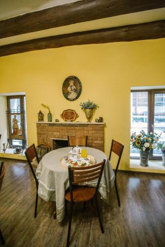 a dining room with a table and chairs and a fireplace at Mariam R in Tbilisi City