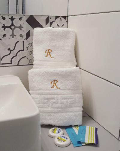 a pile of towels with the r on them in a bathroom at RIMA Del Mar in Eforie Nord