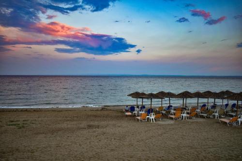 a group of chairs and umbrellas on a beach at Millers Guest House in Kalyves Poligirou