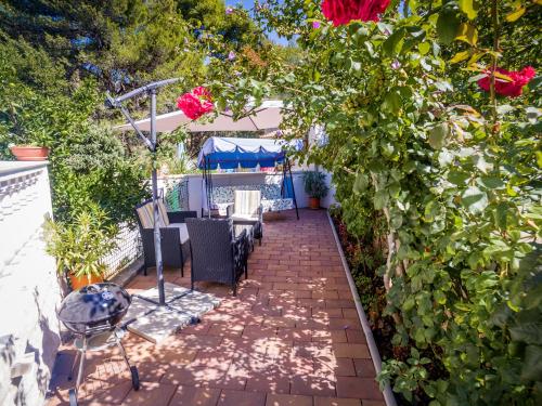 a patio with a table and chairs and roses at Apartment Siesta in Cavtat
