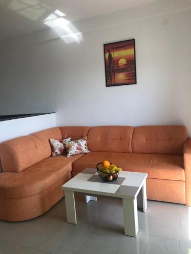 a living room with a brown couch and a table at Apartmani Dini in Ulcinj