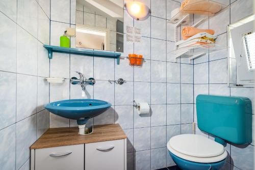 a bathroom with a blue sink and a toilet at Studios Kranjcec in Preko