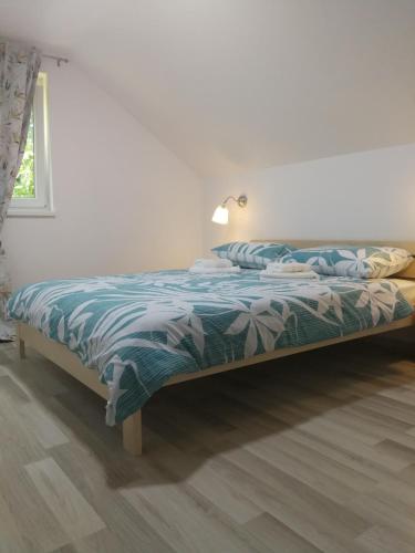 a bed with a blue comforter in a bedroom at New apartment near Plitvice lakes in Smoljanac