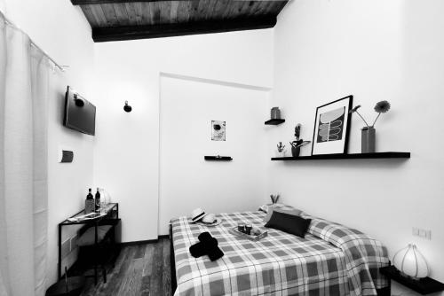 a black and white bedroom with a bed and a desk at Orti di Capalbio in Capalbio