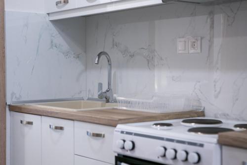 a white kitchen with a stove and a sink at Mihail in Nikiti