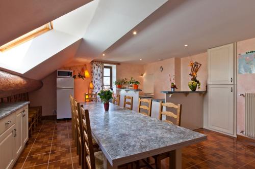 a kitchen and dining room with a table and chairs at Le P'tit Bonheur in Chilly-sur-Salins