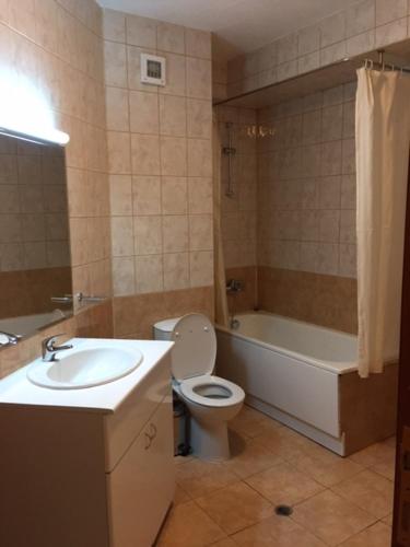 a bathroom with a toilet and a tub and a sink at VIVA Flora apartment 607A in Borovets