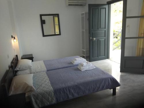 a bedroom with a bed with blue sheets and a door at Arellis in Afitos
