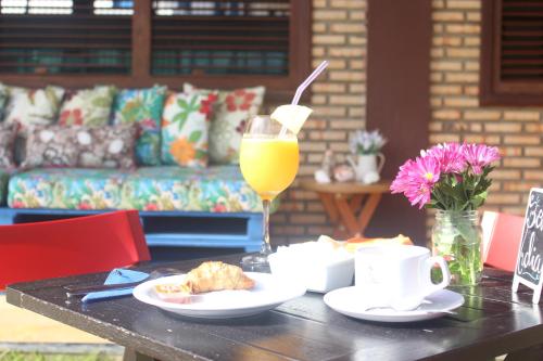 una mesa con un vaso de zumo de naranja y una bebida en Pousada Dona Santinha en Trairi