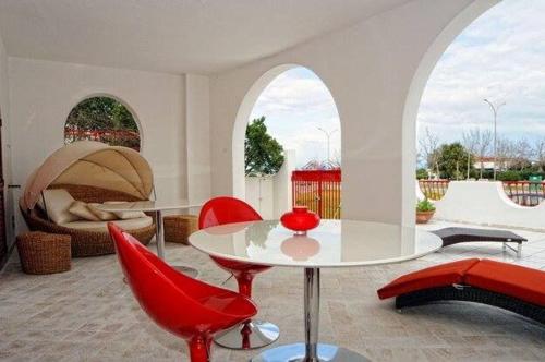 a living room with a table and red chairs at Villa Lulu in Marina di Schiavonea
