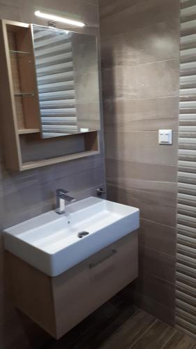 y baño con lavabo blanco y espejo. en Villa Kallimanis, en Platanidia