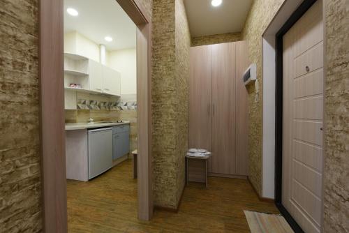 una cocina con armarios blancos y un pasillo en Apart Hotel Clover, en Irkutsk