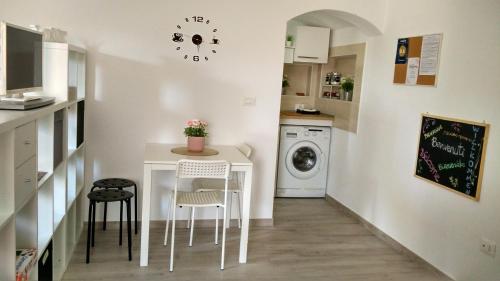 een kleine keuken met een witte tafel en stoelen bij CasaDiPaola in Chieti