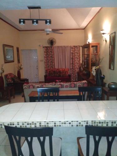 a living room with a table and chairs and a couch at The Residence Portmore Apartments in Portmore