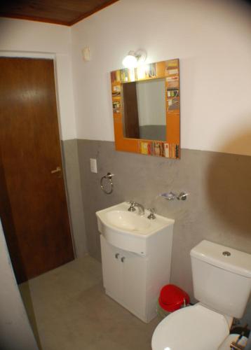 a bathroom with a toilet and a sink and a mirror at Cabañas Cerca Delmar in Mar Azul