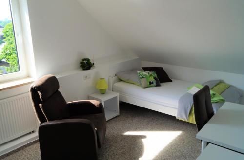 a small bedroom with a bed and a chair at Ferienzimmer Segeberg in Bad Segeberg