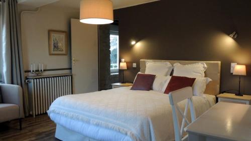 1 dormitorio con 1 cama blanca grande con almohadas en Le Jardin Du Puits, en Longueville