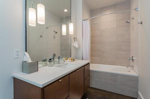 Un baño con lavabo, bañera y ducha. en Mint House at The Reserve - Nashville, en Nashville