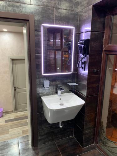 Un baño con un lavabo blanco y un espejo. en Loft Batumi, en Batumi