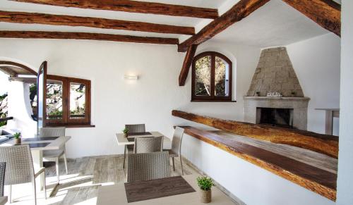 um quarto com uma lareira, uma mesa e cadeiras em Villa Elena B&B experience em Santa Teresa Gallura