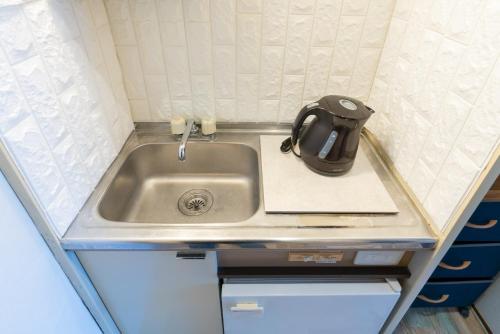 a kitchen sink with a tea kettle on top of it at Dazaifu - Apartment / Vacation STAY 36647 in Dazaifu