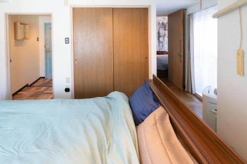 - une chambre avec un lit et un placard dans l'établissement Dazaifu - Apartment / Vacation STAY 36647, à Dazaifu