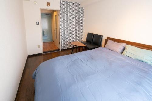 - une chambre avec un grand lit et une chaise dans l'établissement Dazaifu - Apartment / Vacation STAY 36940, à Dazaifu