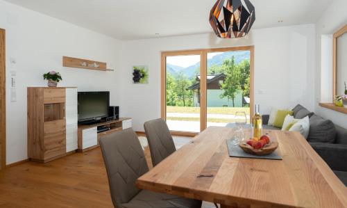 uma sala de jantar com uma mesa de madeira e um sofá em Ferienwohnung App. MOUNTAIN VIEW em Fieberbrunn