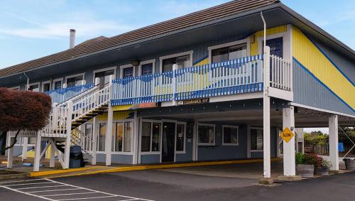 a building with blue and yellow with a parking lot at Seabird Lodge Fort Bragg in Fort Bragg