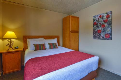 a bedroom with a large bed with a red blanket at Rustic Inn in Moab